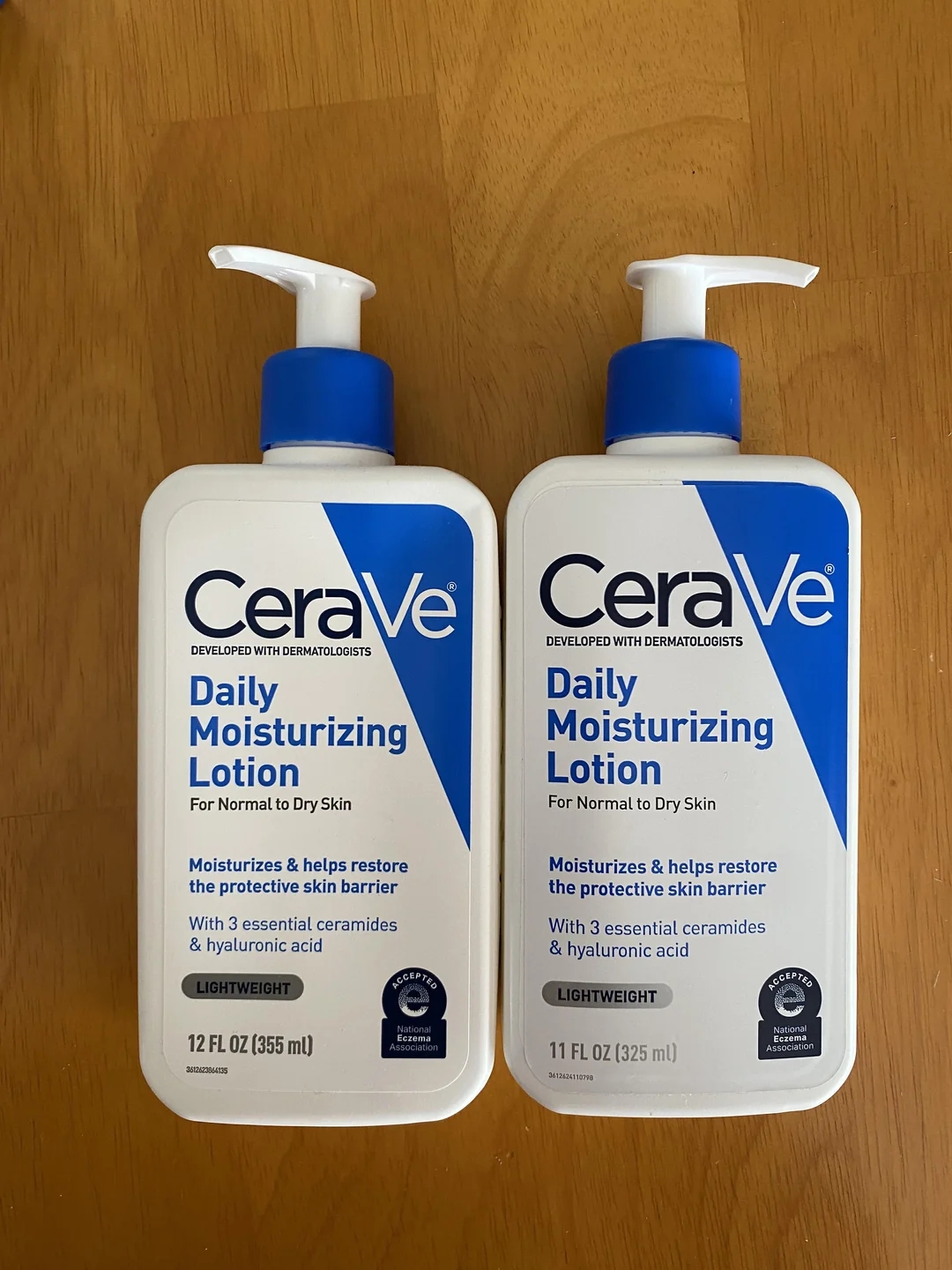 Two bottles of CeraVe Daily Moisturizing Lotion displayed on a table, highlighting skincare for normal to dry skin with ceramides and hyaluronic acid