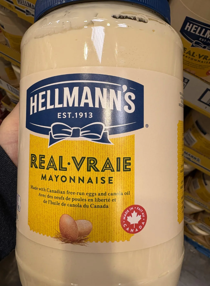 Screenshot of a Reddit post featuring a large jar of Hellman's Real Mayonnaise labeled "Mase in Canada," with comments discussing the typo