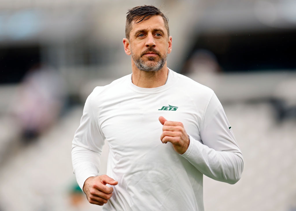A person jogging in a Jets athletic shirt on a football field before a game