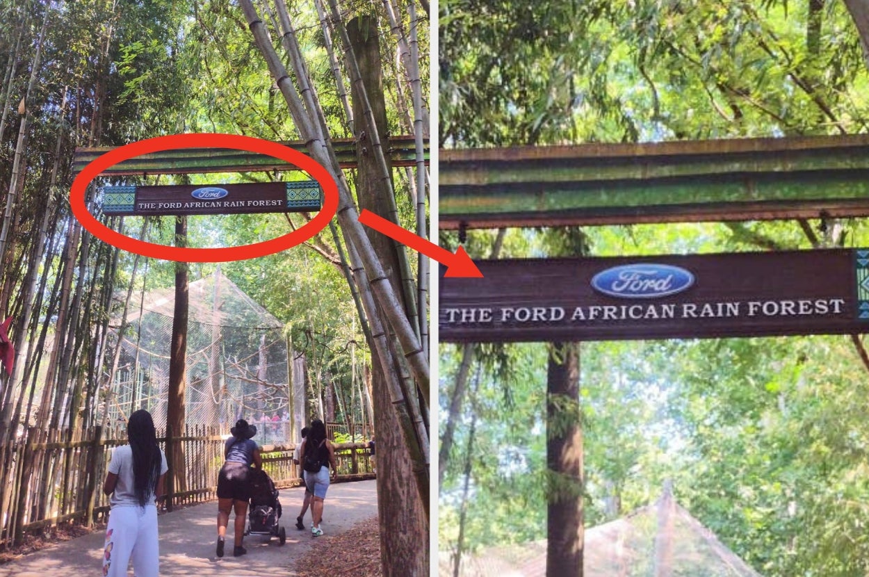 Sign reading "The Ford African Rain Forest" in a zoo; people walking on a path under trees