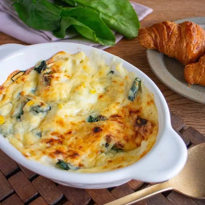 グラタンとクロワッサンが並んでいるテーブル。食欲をそそる焼き色が付いた料理。