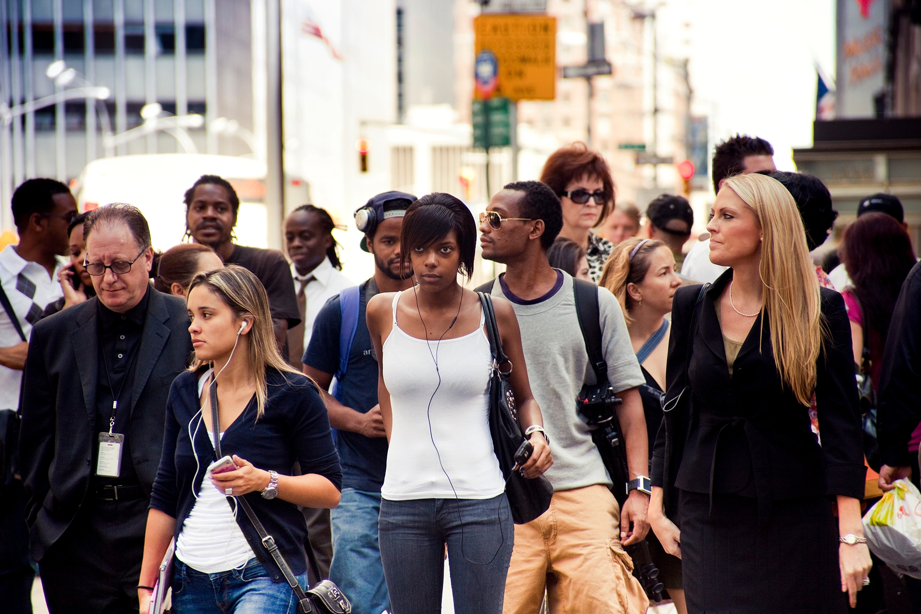 People walking on a busy city street, engaging with each other and their surroundings