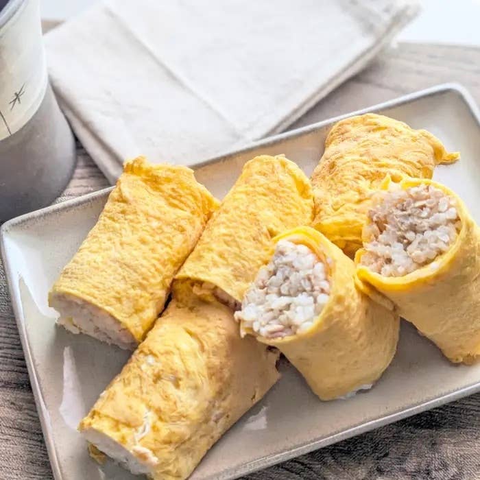 卵で巻かれたご飯のロールが皿に盛られている。シンプルで美味しそうな和食。