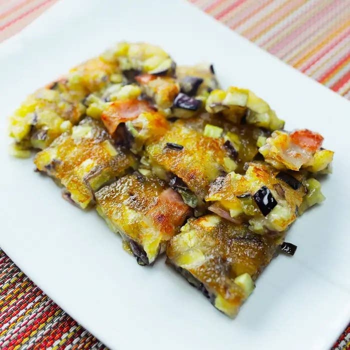 料理の写真。小さく切られた焼き物が皿に並べられている。トッピングは野菜などが見える。