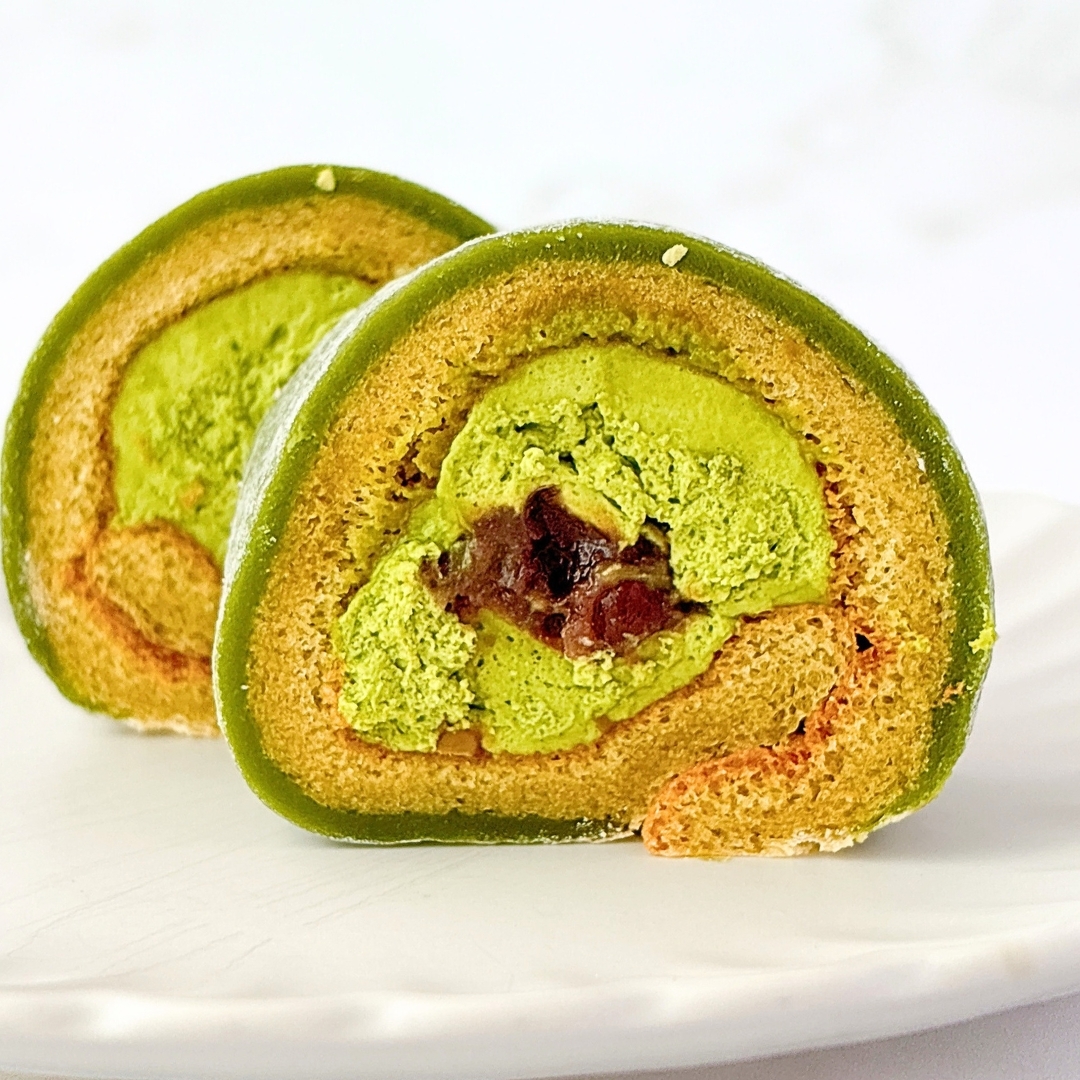 抹茶クリームとあんこを巻いたロールケーキが白い皿に載っている。