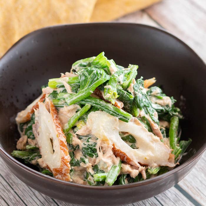 濃厚なドレッシングで和えたほうれん草とレンコンのサラダが、落ち着いたプレートに盛られている。