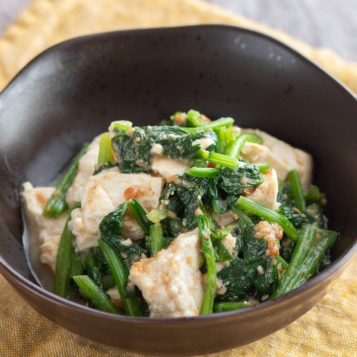 器に盛り付けられたほうれん草と豆腐の和風サラダ。健康的な食事。