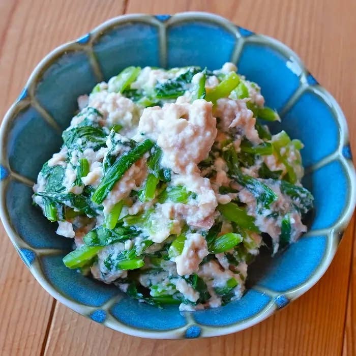 小松菜と豆腐の白和えが青い器に盛られている。日本料理の一品。
