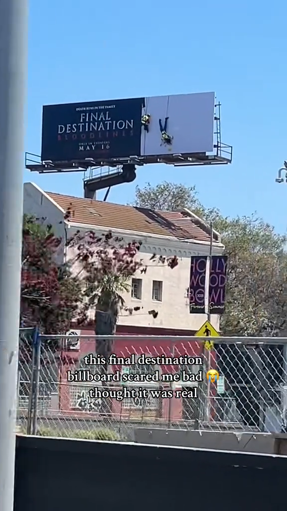 Billboard with "Final Destination 6" movie ad appears as if two people are climbing it, creating a realistic, startling illusion for passersby