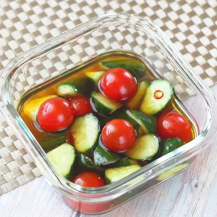 透明な容器に入ったトマトときゅうりのサラダ。