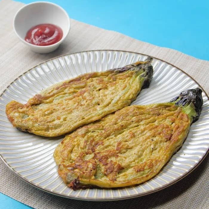 皿に盛られたナスのソテー2切れ。横にケチャップの小鉢。