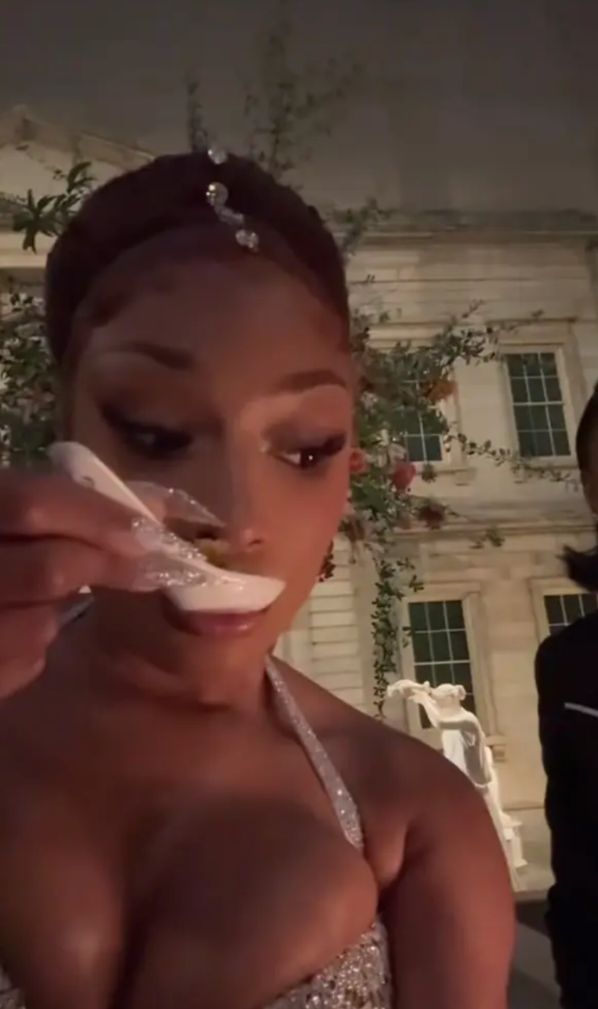 Megan Thee Stallion eating with a spoon at an event