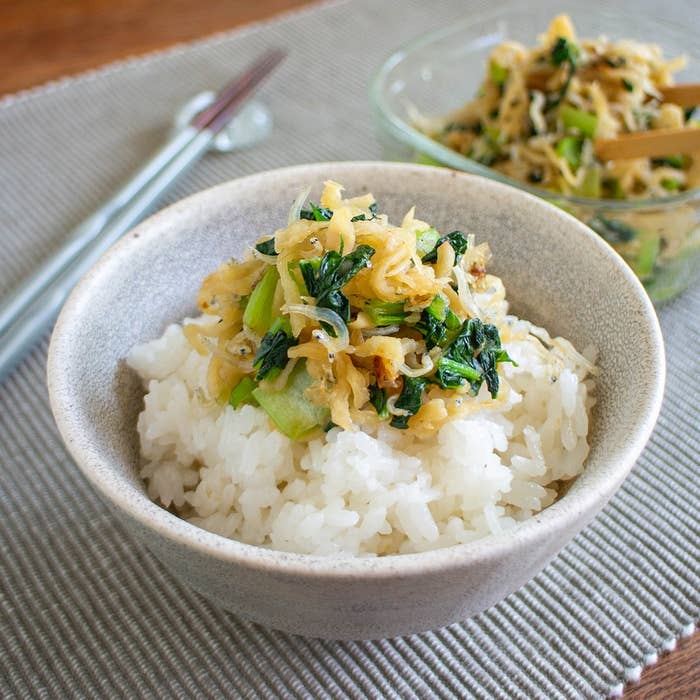 白いご飯の上に野菜炒めがのったお茶碗と、後ろに同じ料理の入ったボウル。