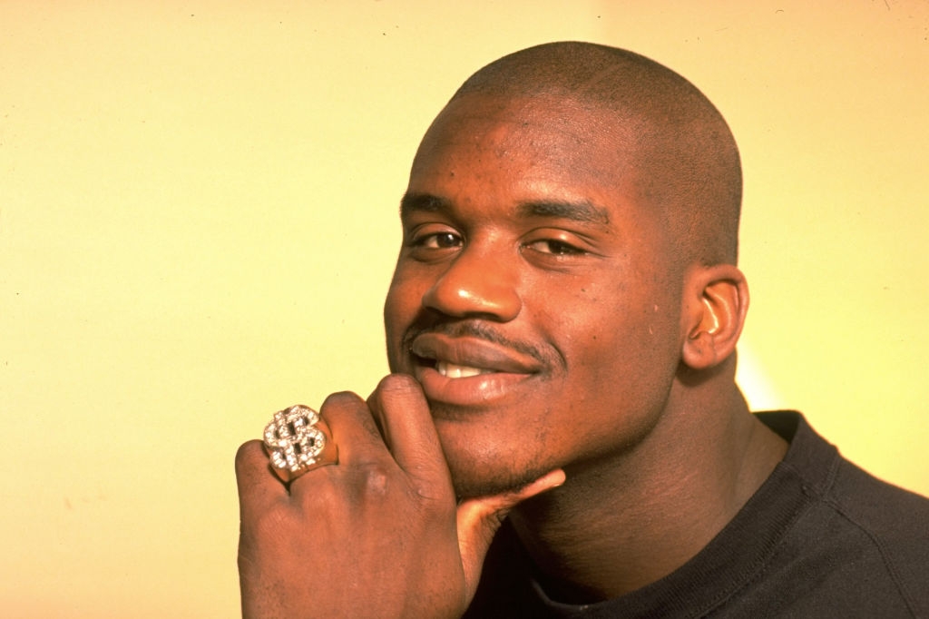 Person smiling, resting chin on hand, wearing a large ring