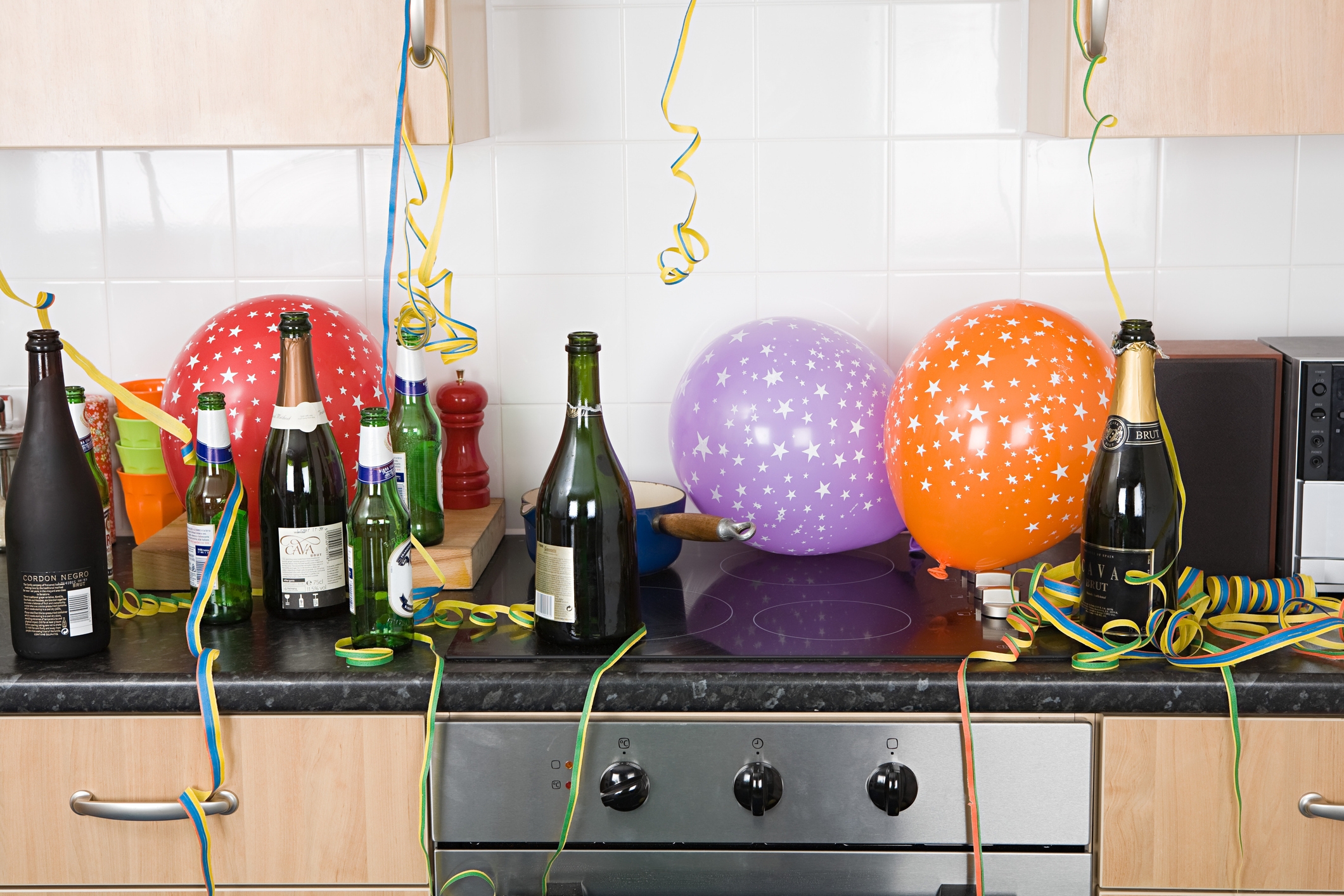 Kitchen countertop with balloons, streamers, and empty bottles, suggesting a celebration or party