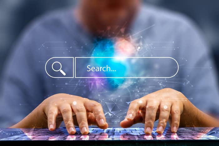 Person typing on a virtual keyboard with a digital search bar above, symbolizing internet browsing or online search activity