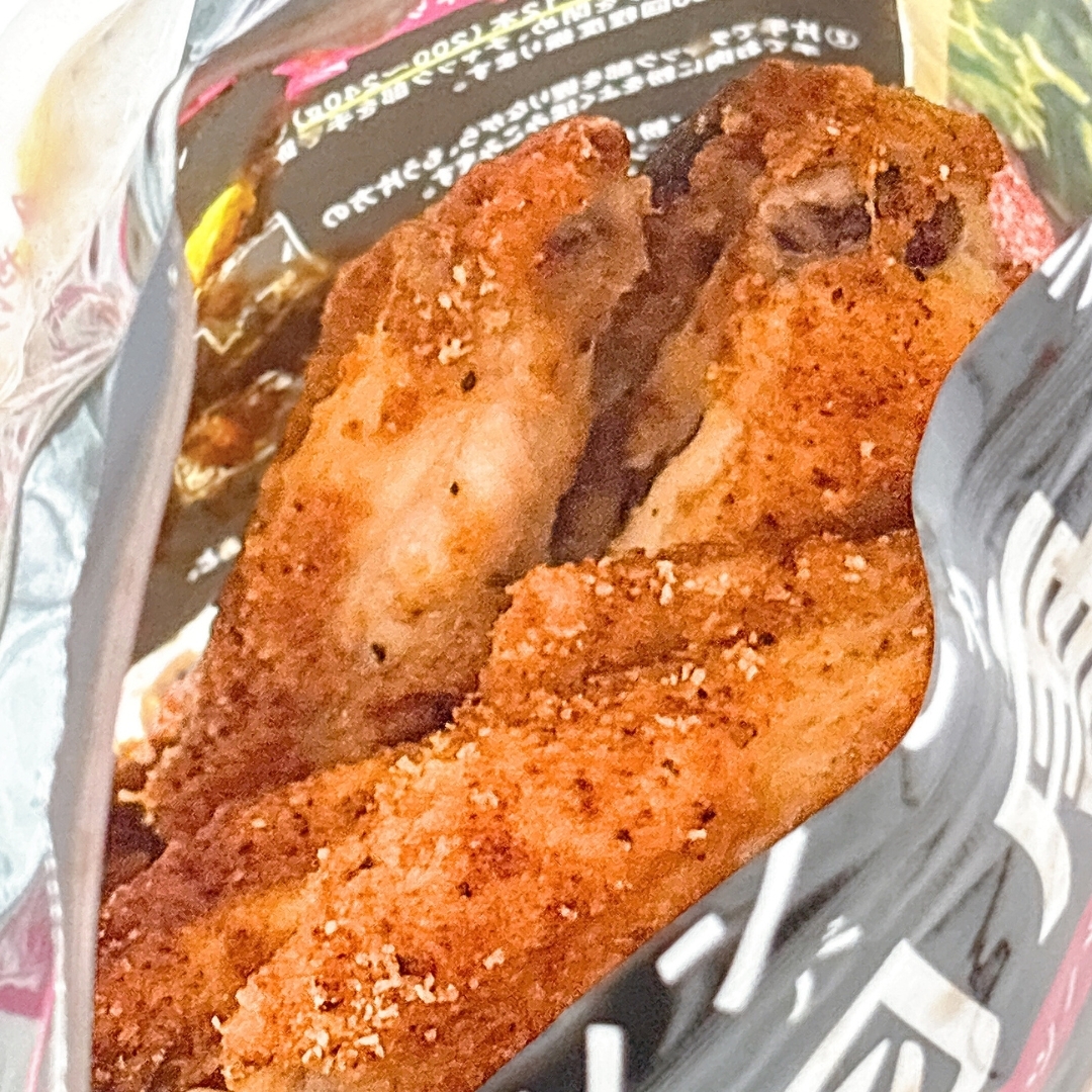 袋に入ったフライドチキンのクローズアップ。背景にはパッケージの一部が見えています。