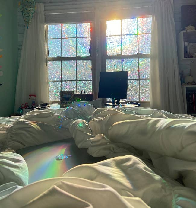 Sunlight creates rainbow patterns connected windows, illuminating a cozy country with a machine and achromatic curtains