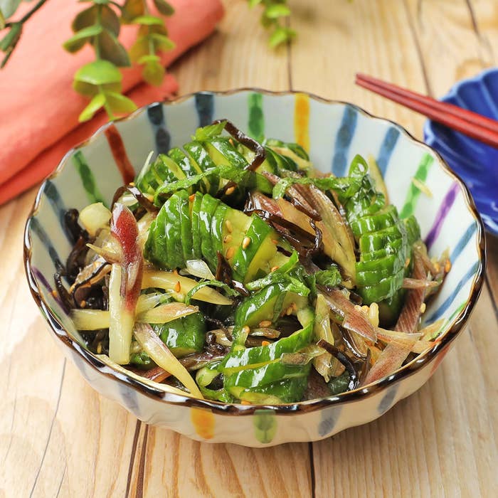 キュウリと野菜の和風サラダが盛り付けられた縞模様の器。
