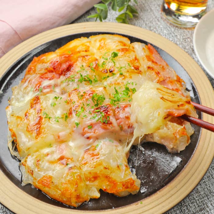 チーズがたっぷりとかかった熱々のパリッとした料理が皿に盛られている。