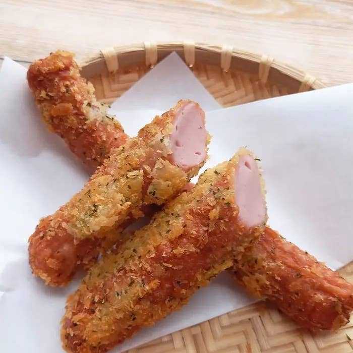 かごに盛られた揚げたホットドッグ4本。切り口が見えるものもあります。