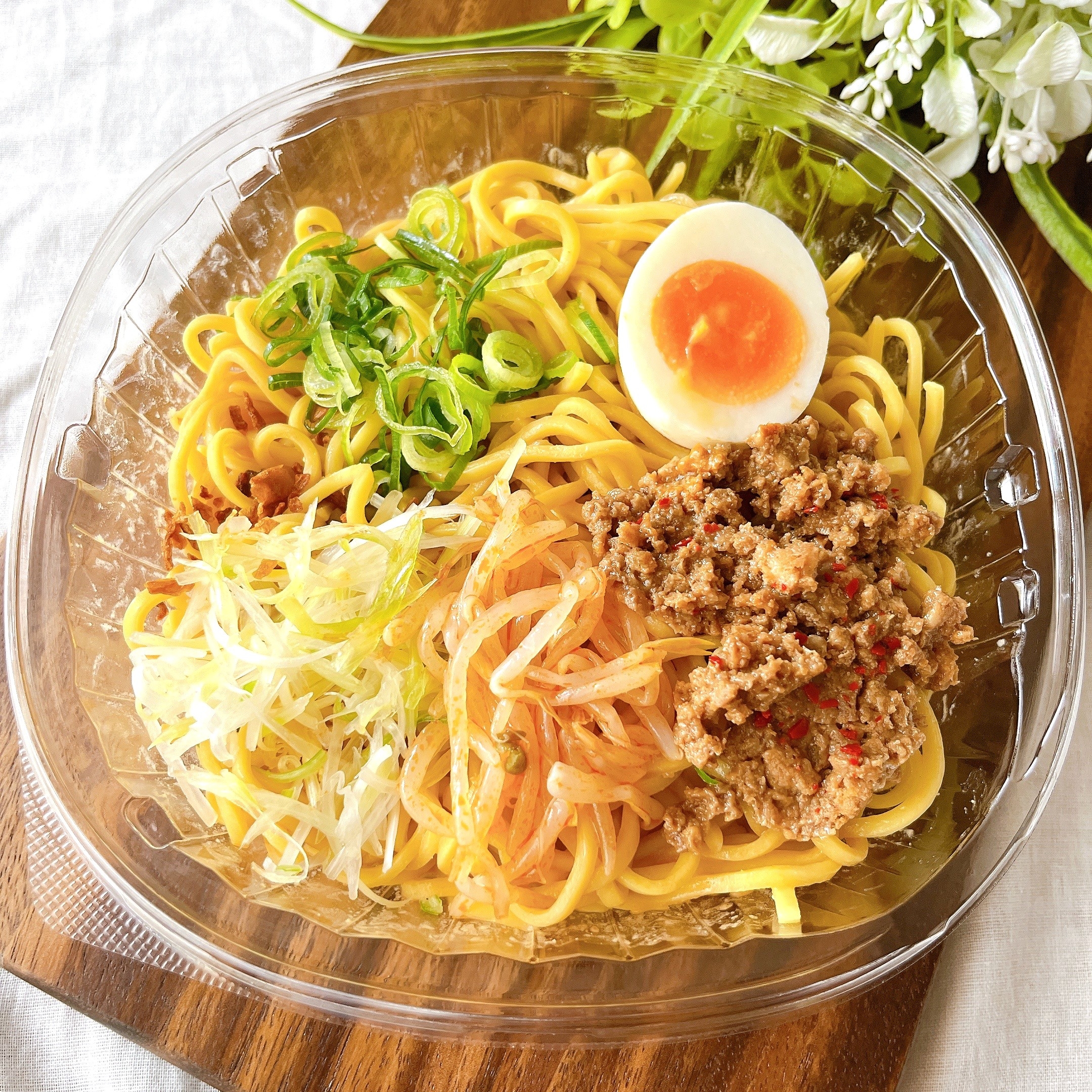 皿に盛られた冷やし中華。ゆで卵、肉そぼろ、ネギ、もやしがトッピングされた麺。