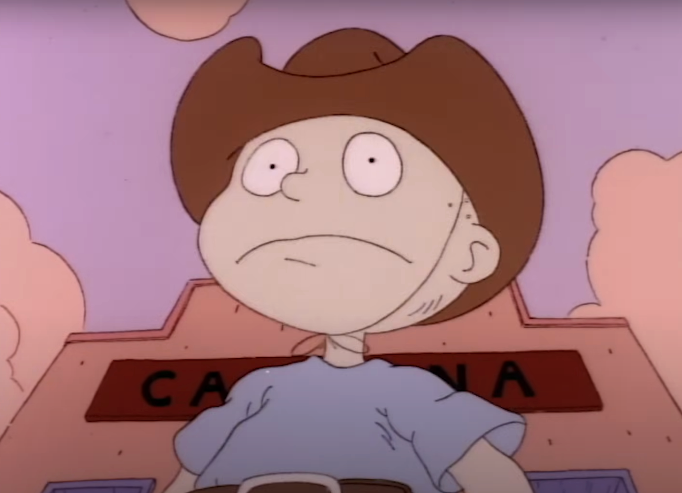 Animated character wearing a cowboy hat, standing in front of a building with partial &quot;CARNIVAL&quot; sign visible