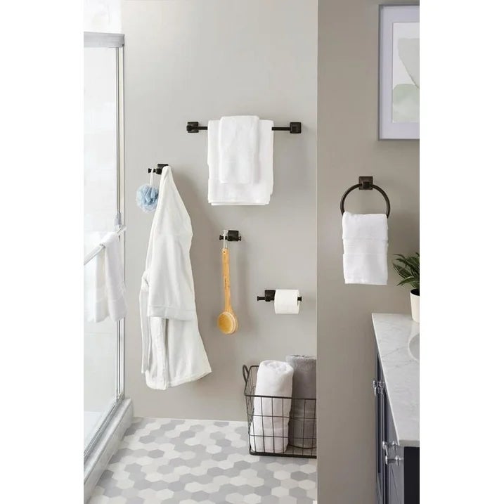 Bathroom with towel racks, a robe, a ablution  brush, toilet paper, and a ligament  basket. Geometric tile level  and partial ablution  view