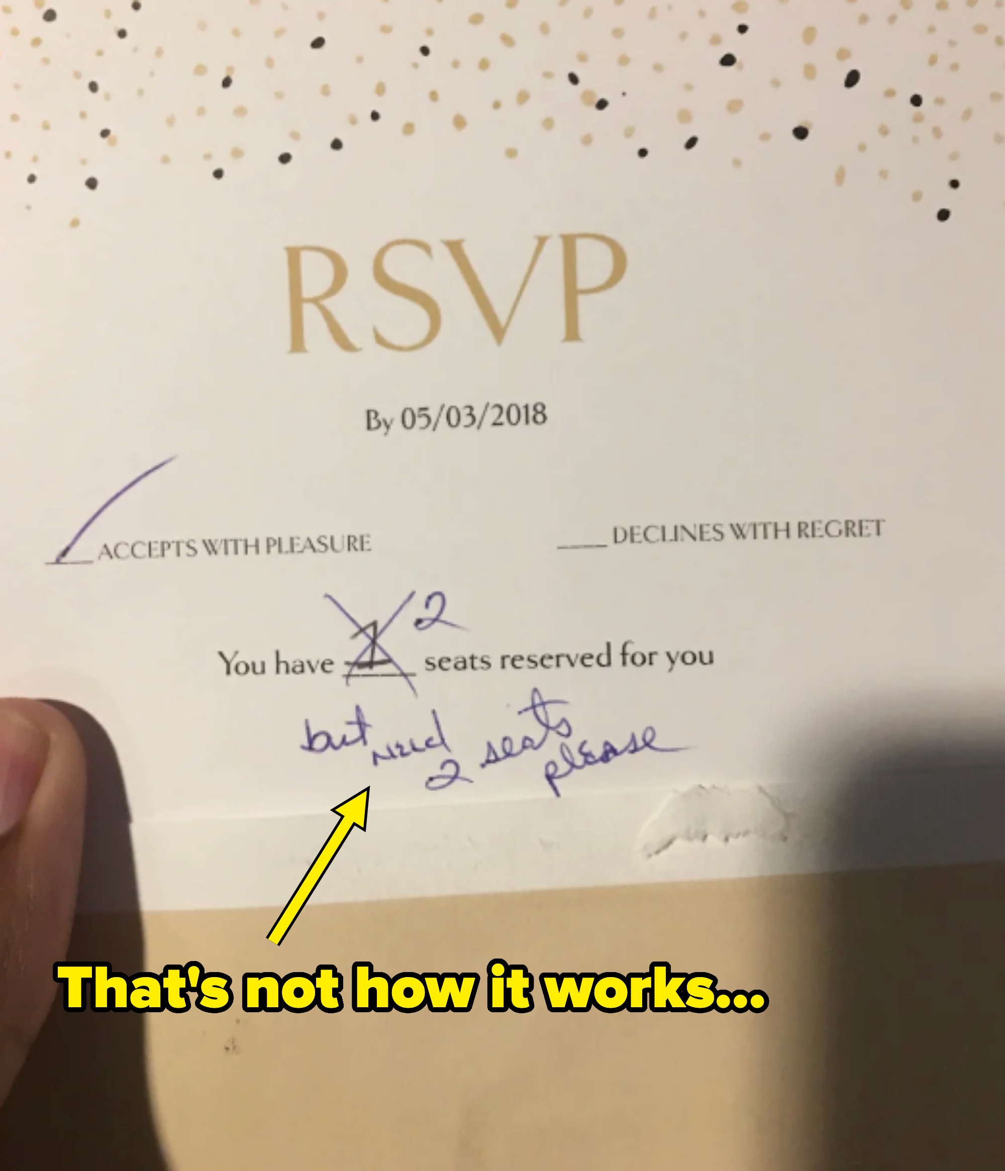 RSVP card stating "you have 1 seat reserved for you," returned with the 1 crossed out and the guest having written "need 2 seats please"
