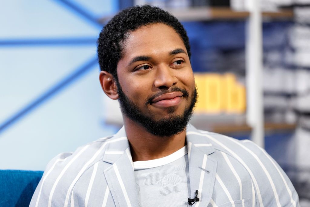 Persona con chaqueta de rayas y camiseta clara, sentado en una entrevista de TV, mirando hacia un lado con una expresión relajada