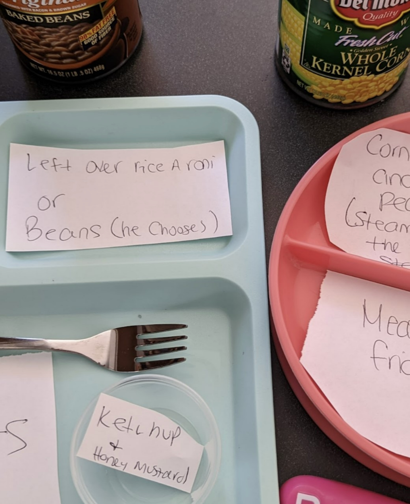 Meal prep for kids with two divided plates: one with corn, meatballs, and a note on peas; another with dino nuggets and a ketchup note