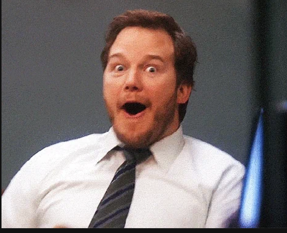 Person with surprised expression, wearing a white shirt and tie, sitting down