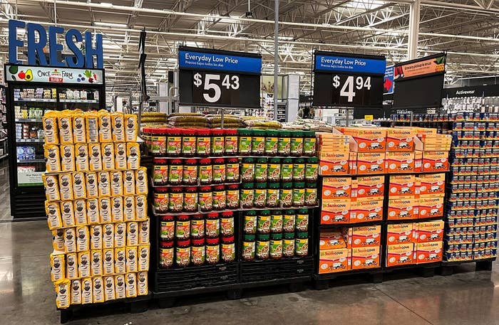 Grocery store display with various packaged foods and signs showing prices $5.43 and $4.94