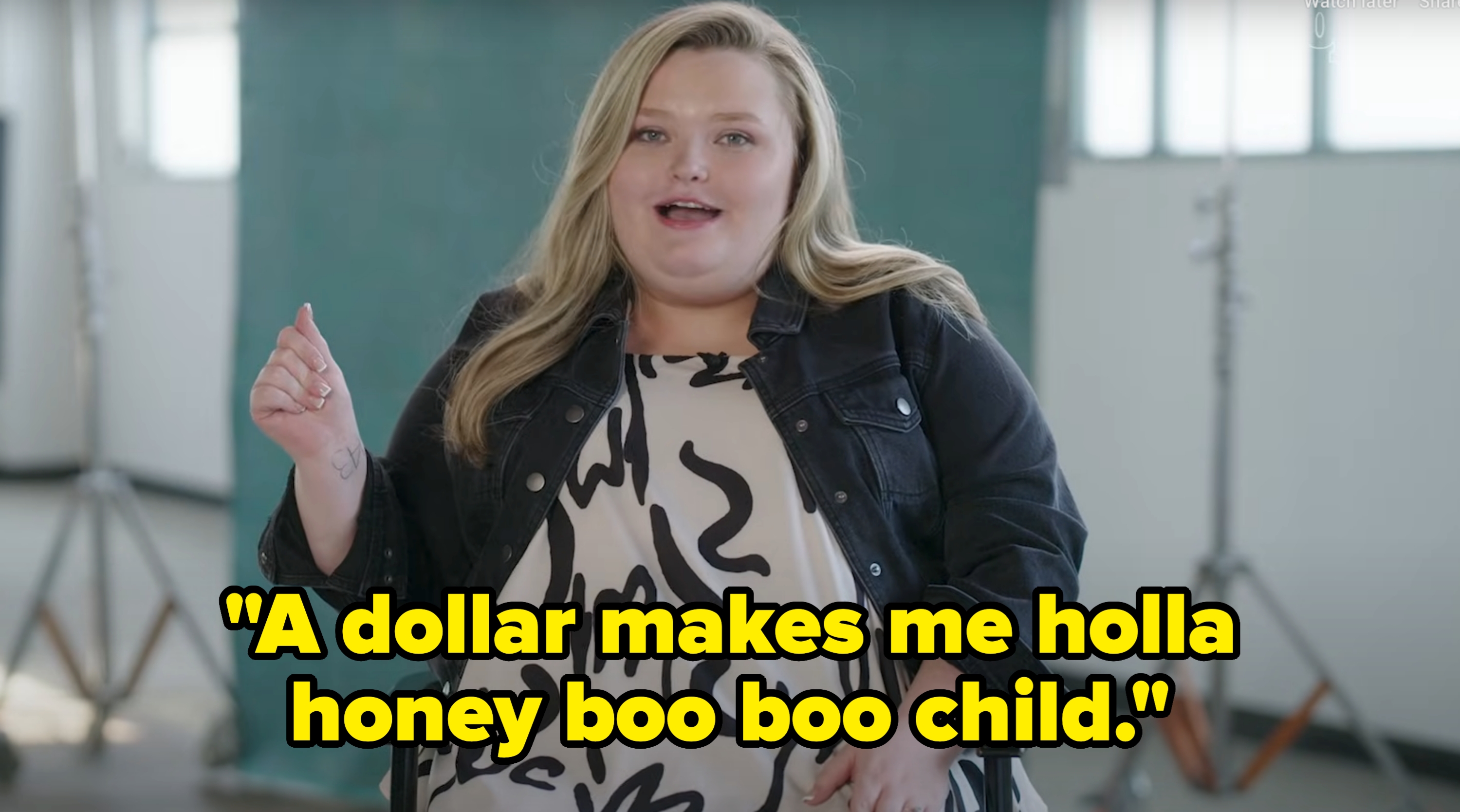 Person speaking, wearing a denim jacket and patterned dress in a studio setting