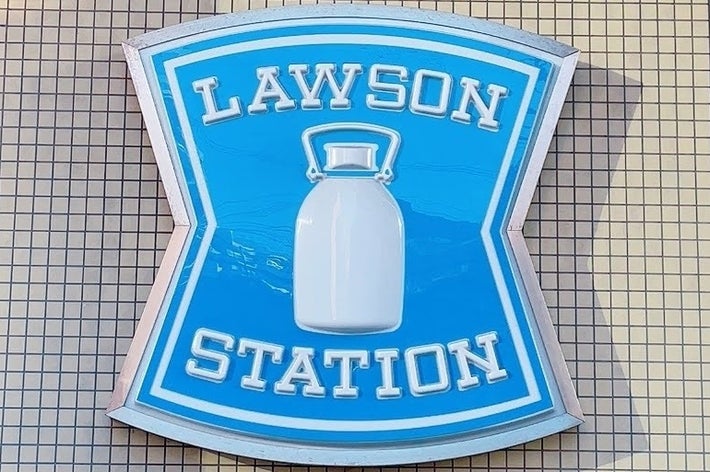 「LAWSON STATION」と書かれた看板が建物の外壁に取り付けられている。