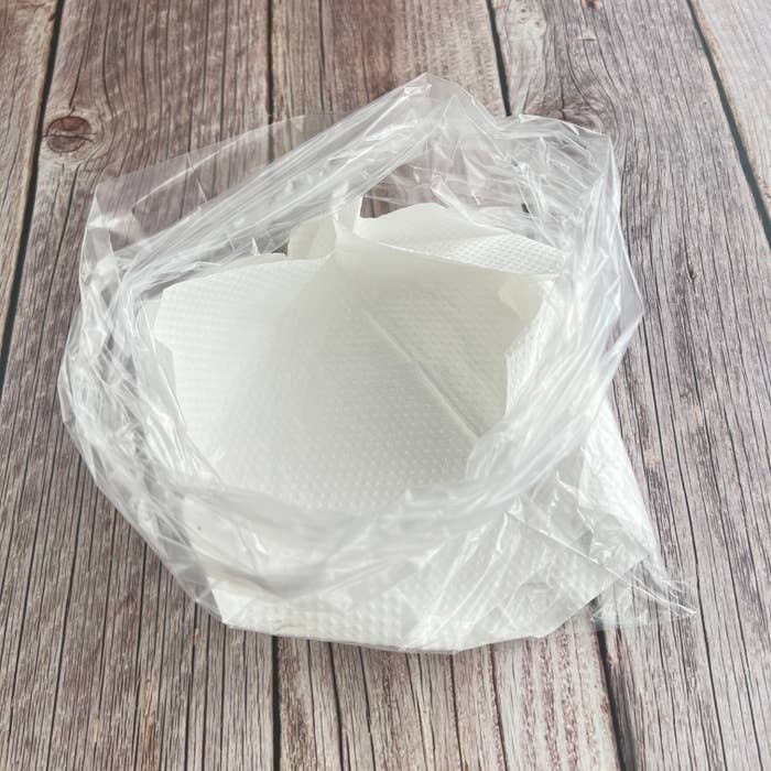 テーブルに置かれた透明なプラスチック袋に白いペーパーナプキンが入っている。