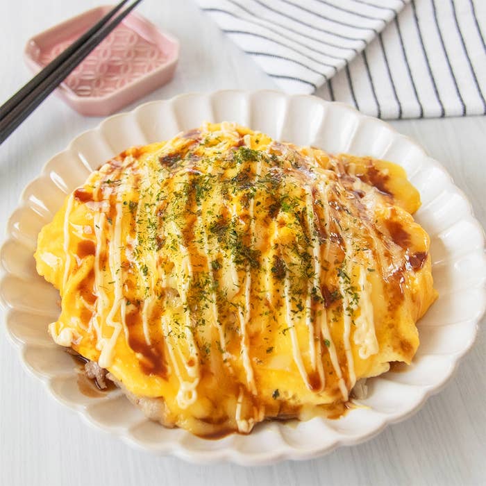 とんぺい焼きが白い皿に盛られている。上にマヨネーズとソースがかかり、のりが振りかけられている。