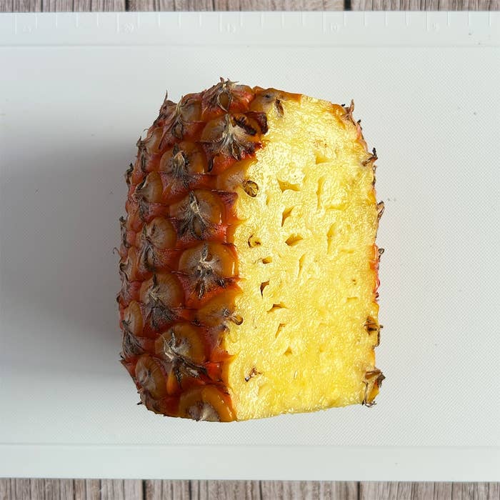 カットされたパイナップルの断面がまな板に置かれている。