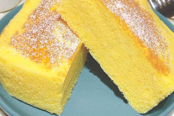 お皿に盛られた、ふんわりした厚みのある二切れのカステラケーキが見えています。