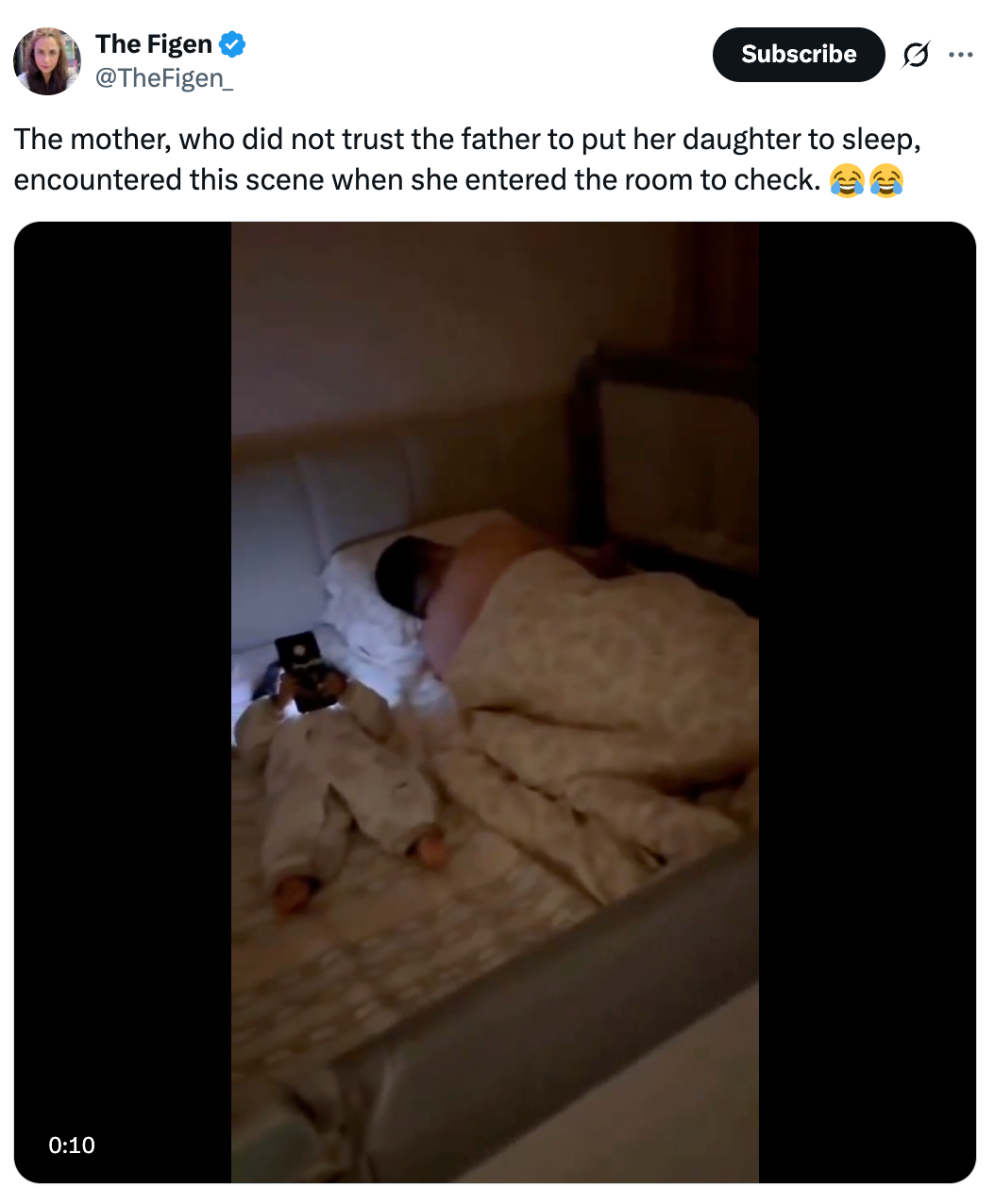 A man and a baby are lying in bed. The baby is holding a phone, mirroring the man's sleeping position