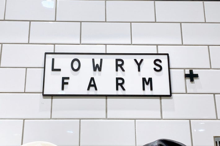 LOWRYS FARMのロゴが壁に掲示されている。シンプルでモダンなデザイン。