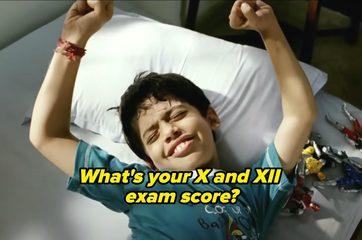 Child smiling with eyes closed, laying on a pillow, stretching arms. Action figures lie beside them on the bed