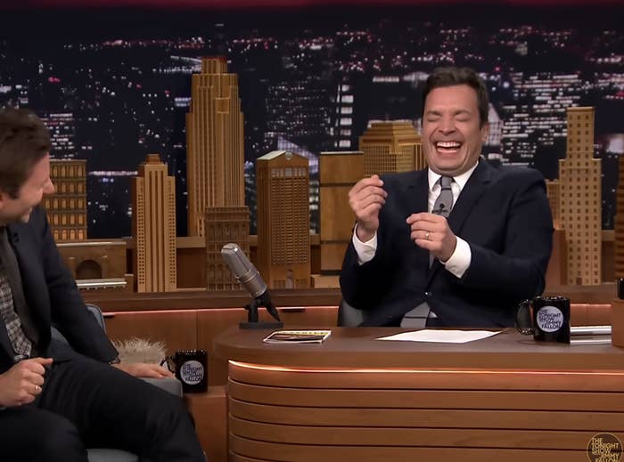 Jimmy Fallon laughing with guest Bradley Cooper on a late-night show set