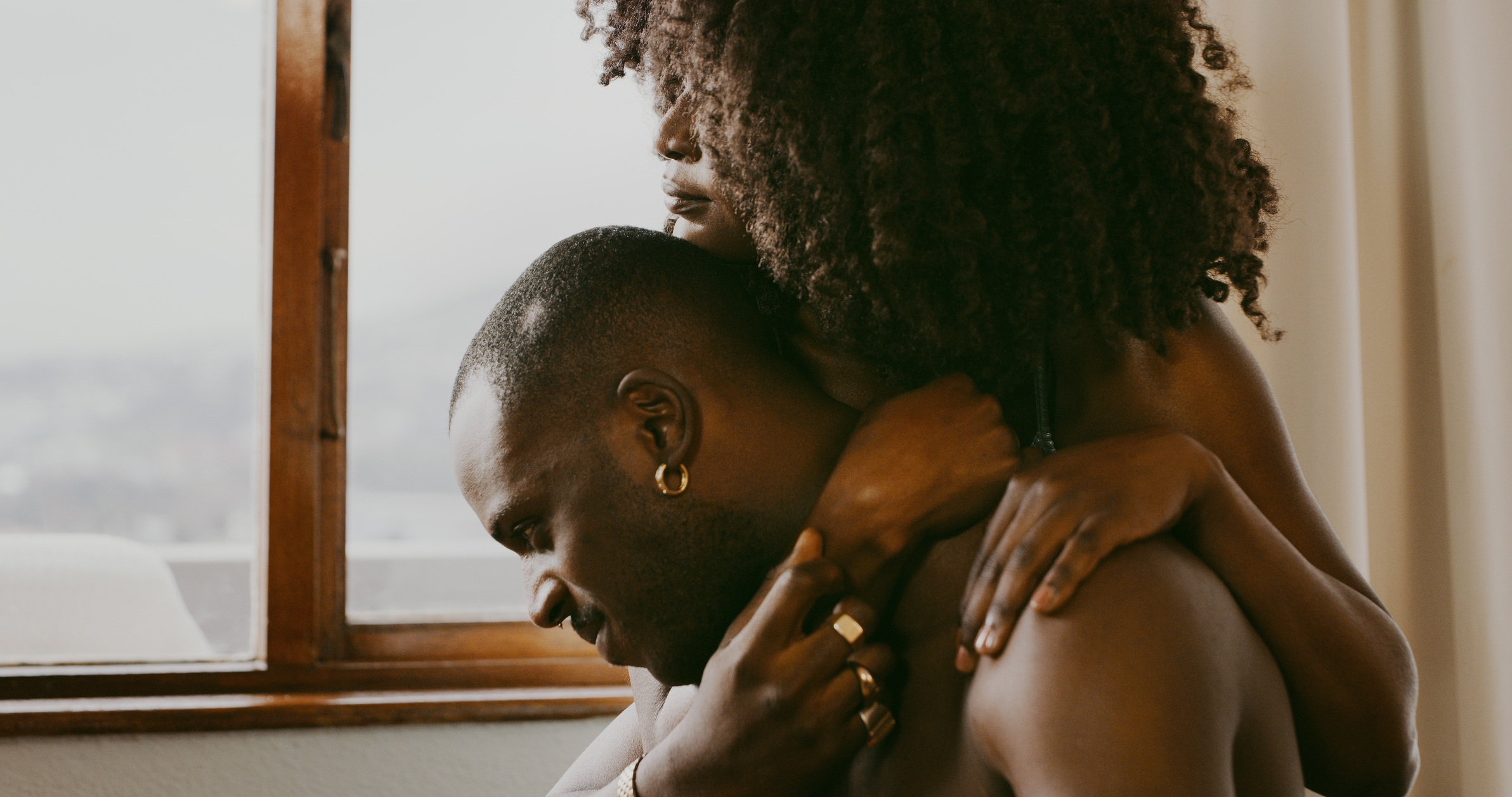 Two people embracing near a window, showing affection and connection