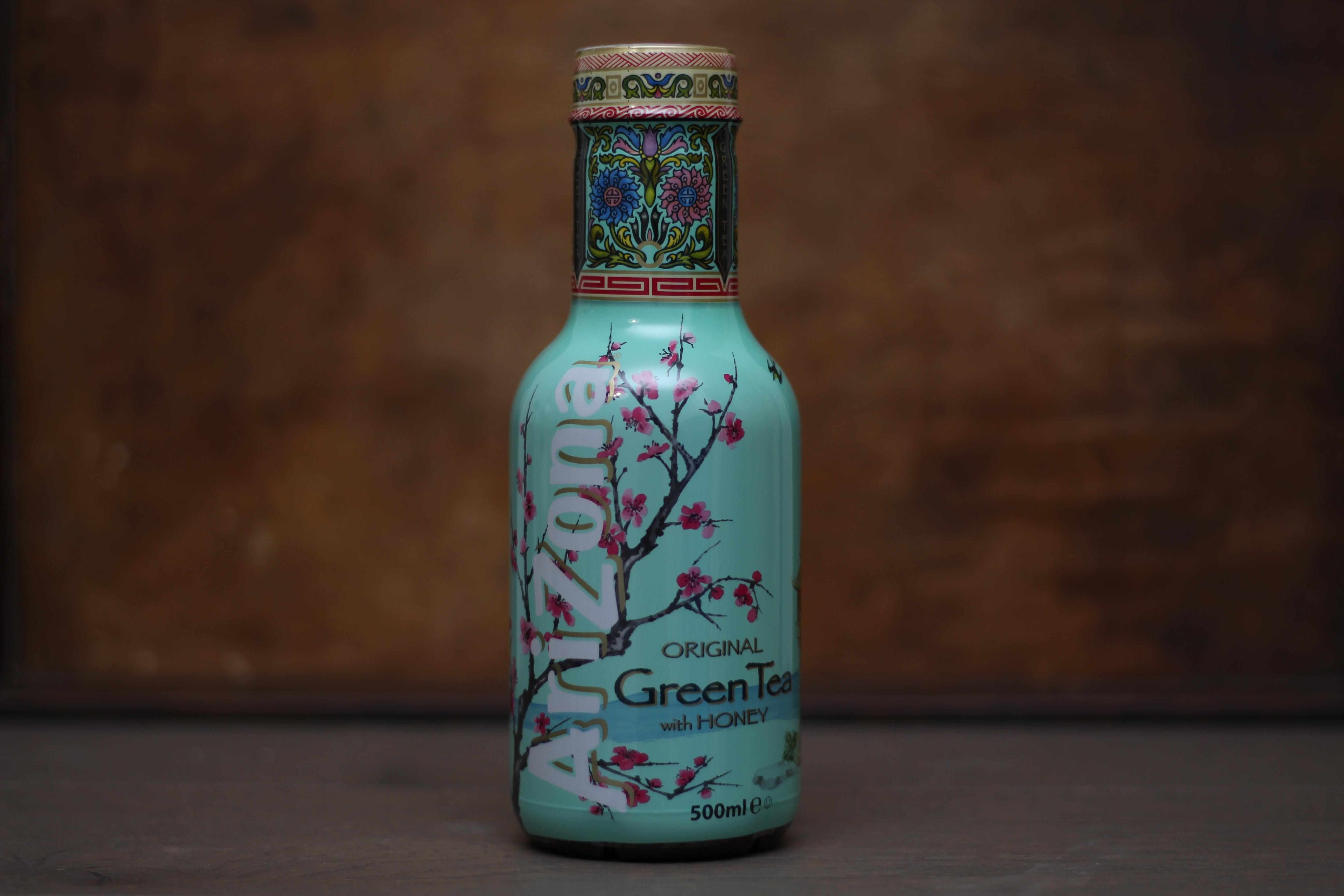 Bottle of Arizona Green Tea with Honey featuring floral designs and a decorative cap