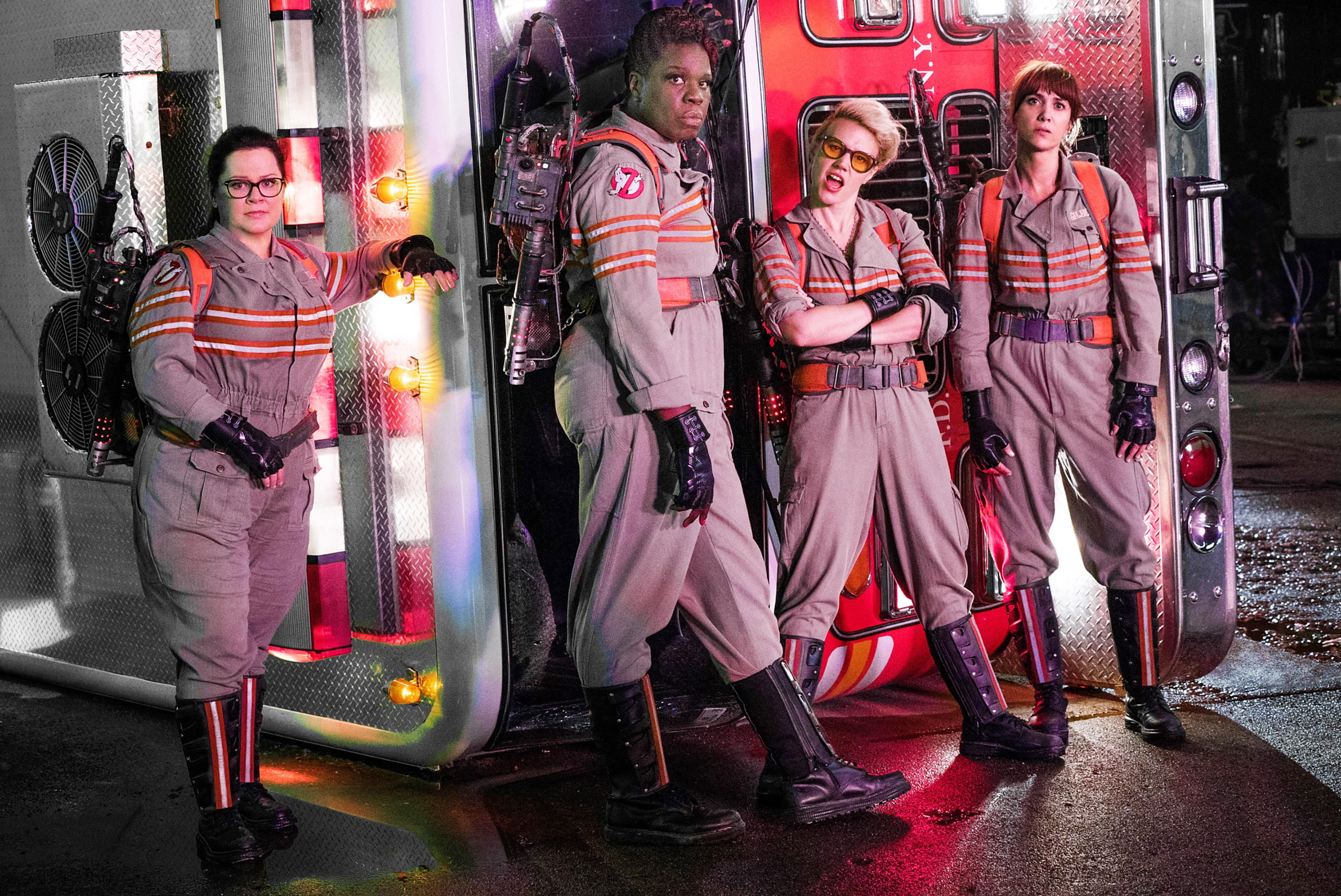 The Ghostbusters in uniform pose in front of a firetruck