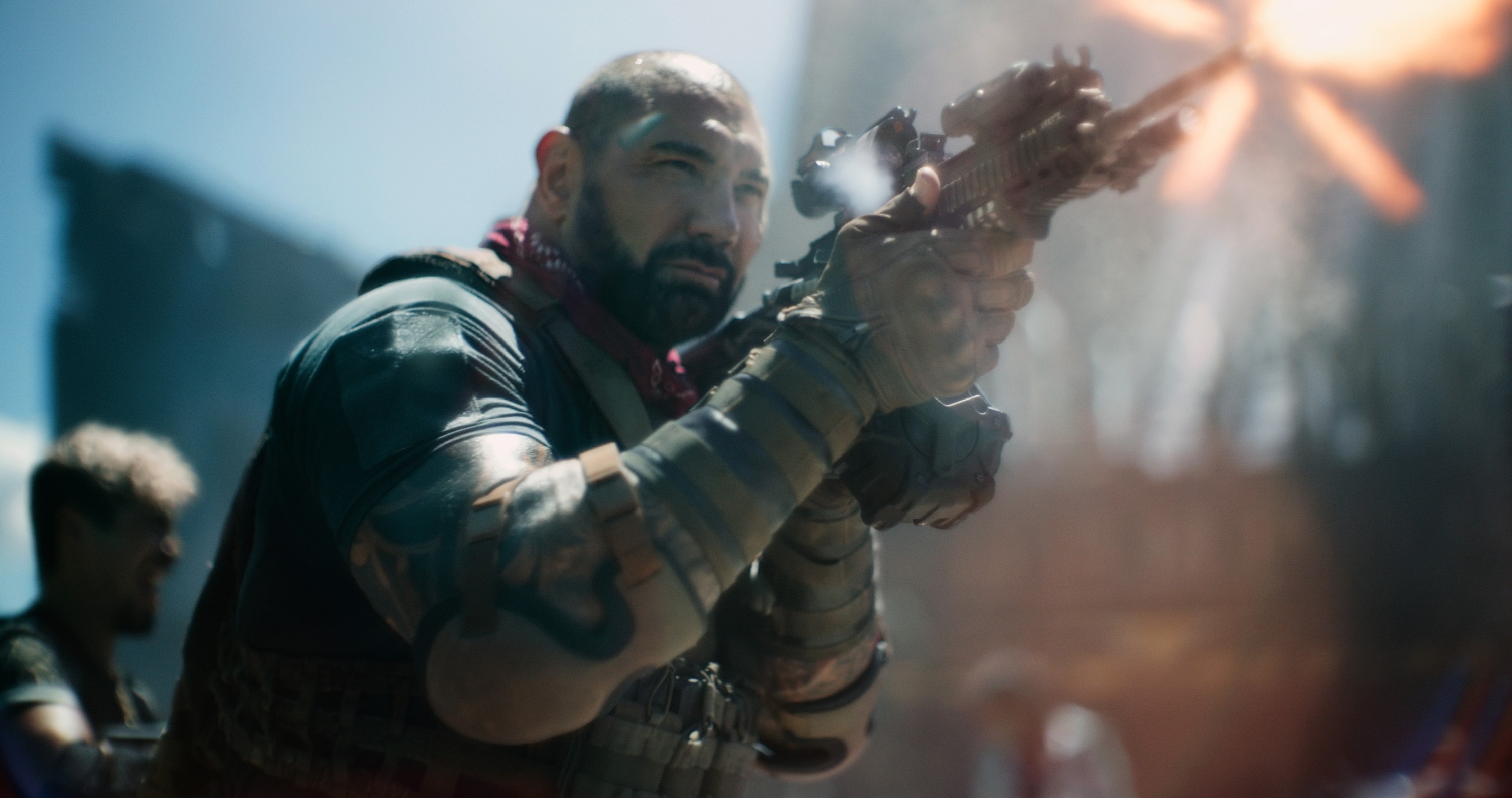 Bautista holds a weapon, dressed in tactical gear, in an intense action scene