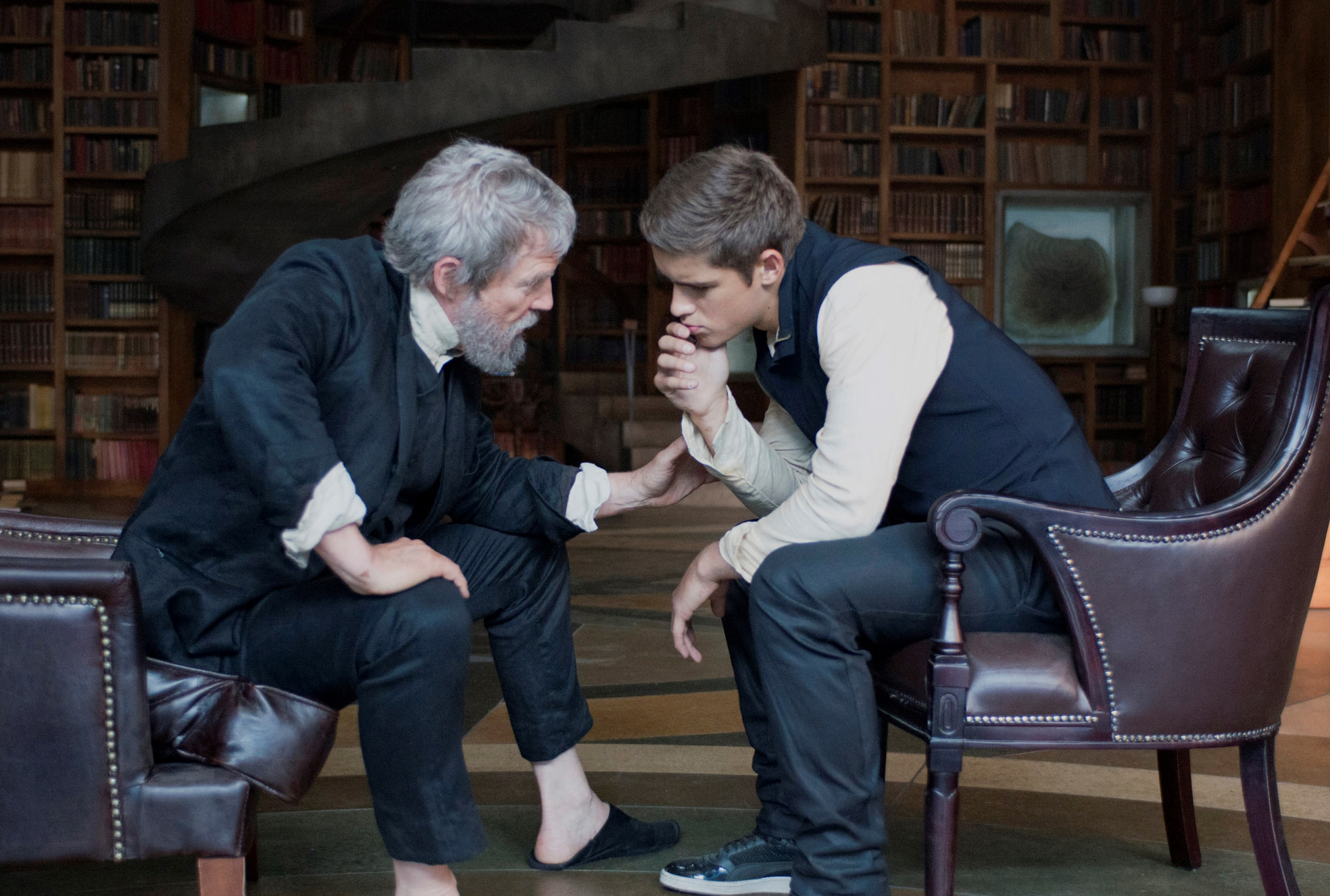 The Giver and Jonas sit facing each other in a library