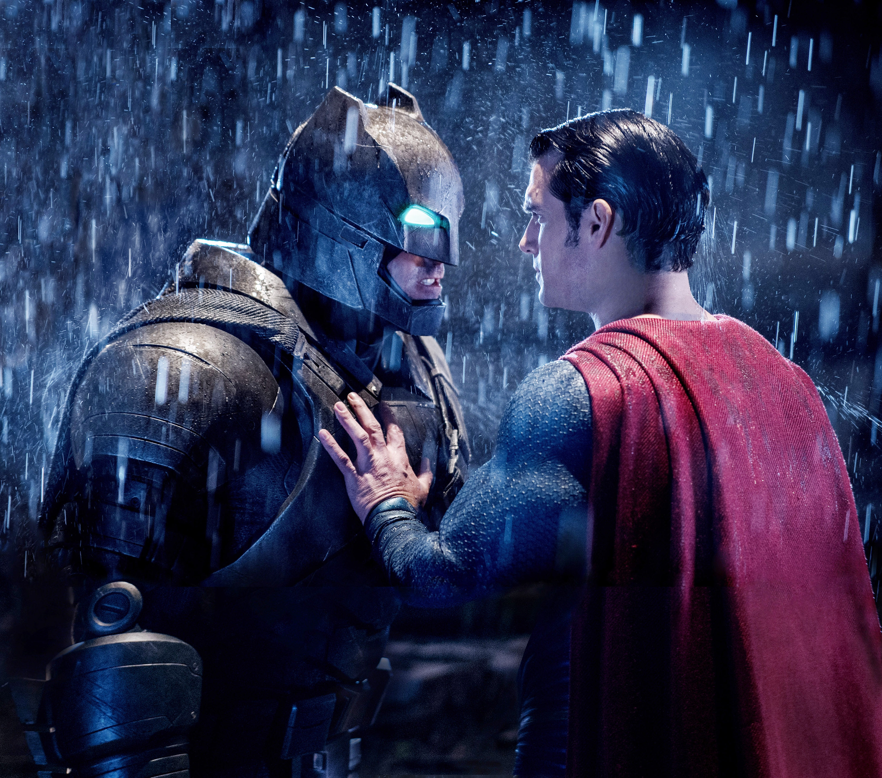 Superman with his hand on Batman's chest in the rain