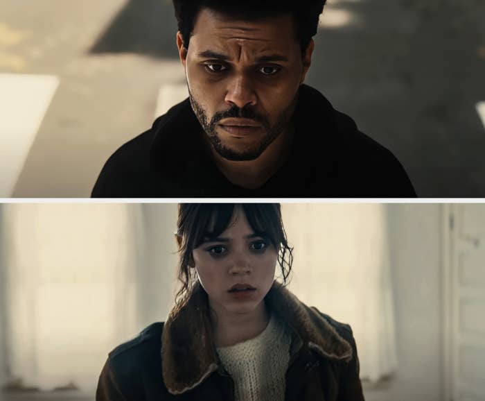 A man looks serious, wearing a dark hoodie and has short hair. He is outdoors with a blurred background